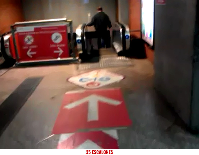 Foto flecha en el suelo señalando hacia escaleras mecanicas paradas en la Estación de Atocha Cercanías-Renfe de Madrid